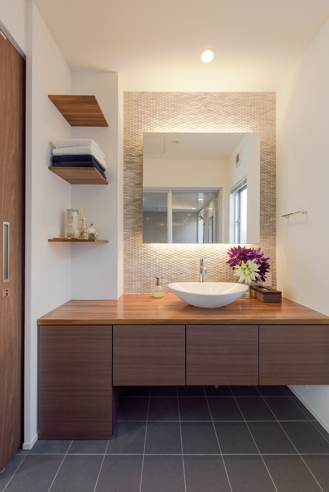 造作の洗面スペース
間接照明を入れた正方形の鏡や、高級感あるグレーのタイルがホテルライクな空間を演出しています