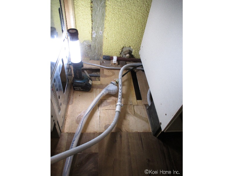 工事中
フローリングをはがし、既存の給湯管・排水管は止栓して、シンクより延長ホースで配管しています。オーブンが隣なので、天板にも固定しています。