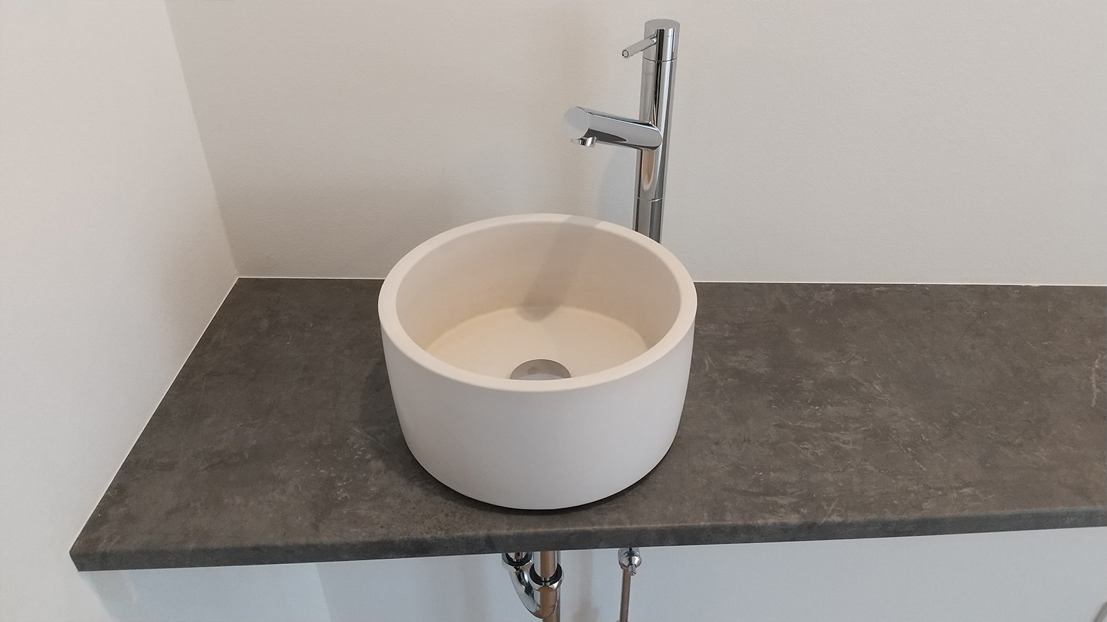 玄関そばには陶器のような温かみのある洗面ボウルを使った造作の洗面台